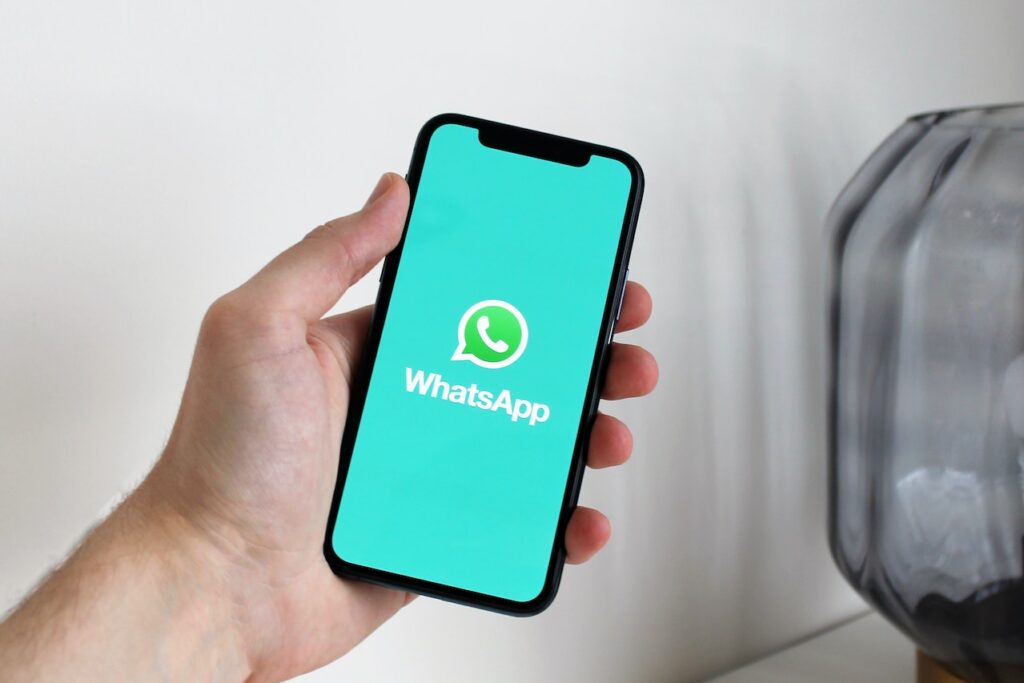 Hand holding a Smartphone displaying WhatsApp